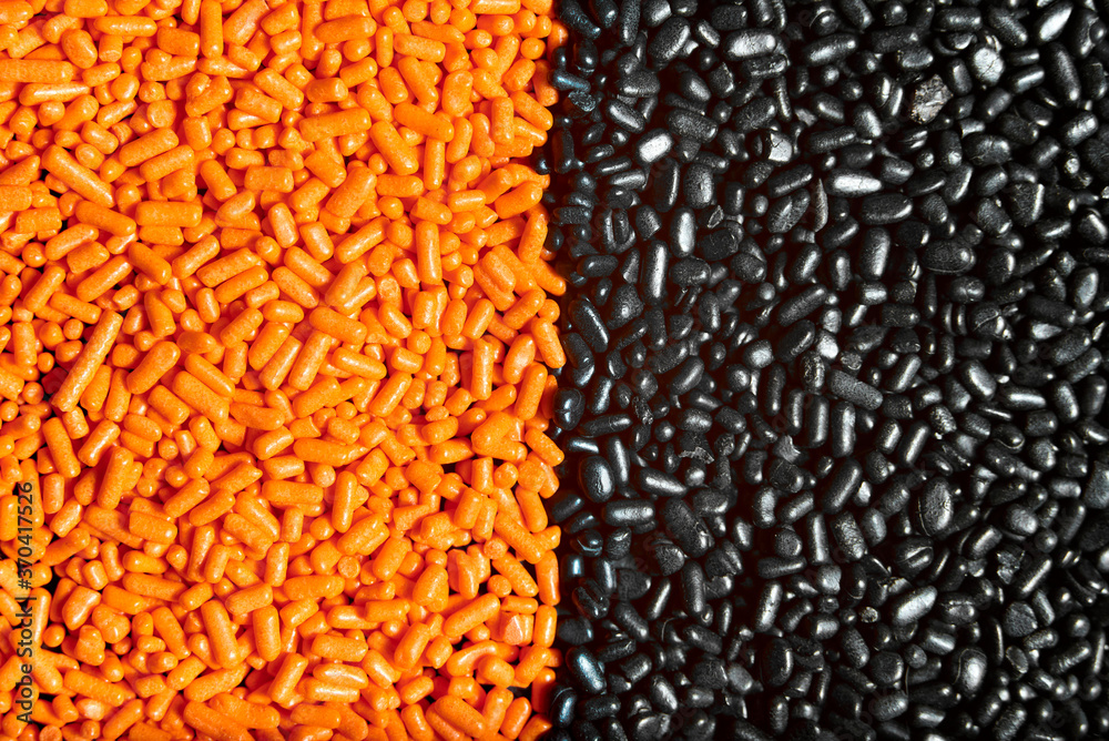 Orange and black unmixed sprinkles macro background, halloween theme