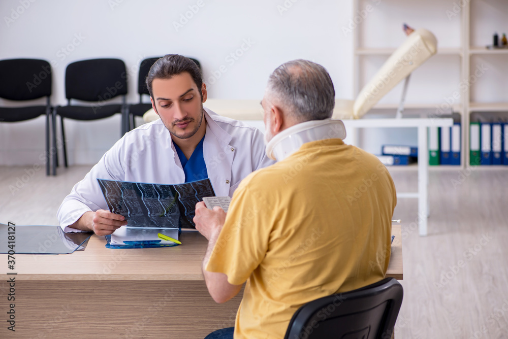 Fototapeta premium Old neck injured man visiting young male doctor radiologist