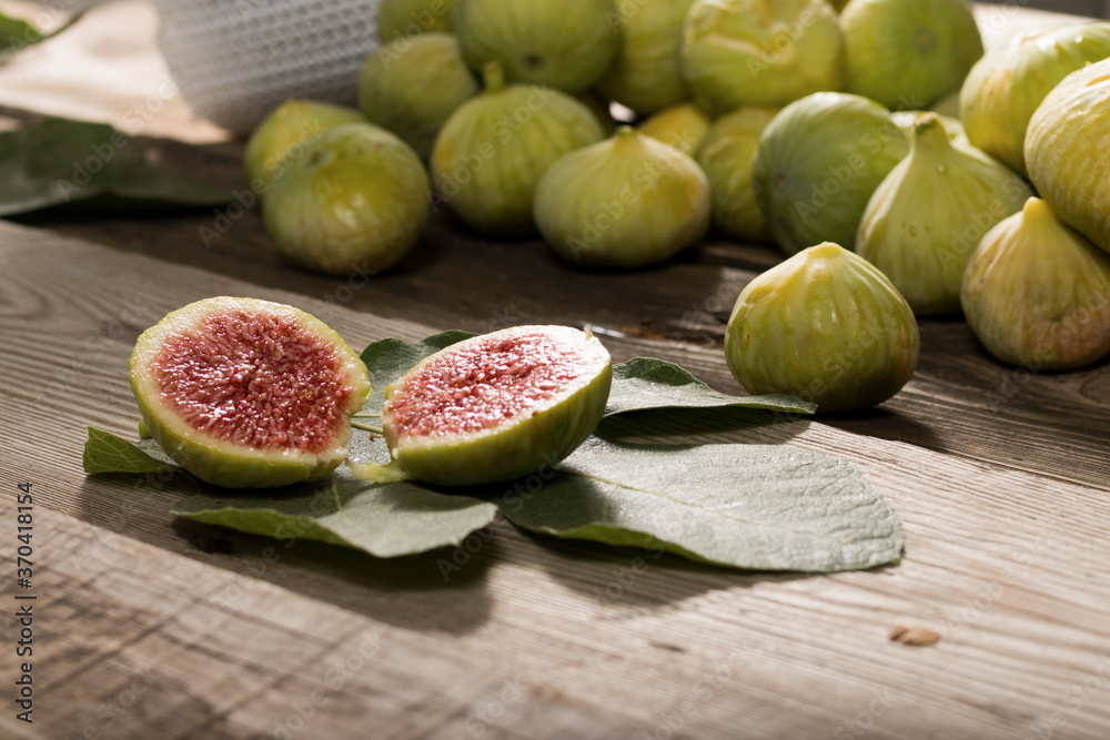 Green Figs, cut slices and leaves on old wooden table Green Figs, cut slices and leaves on old wooden table