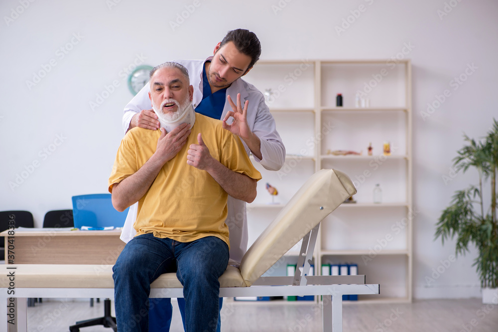 Obraz premium Old neck injured man visiting young male doctor