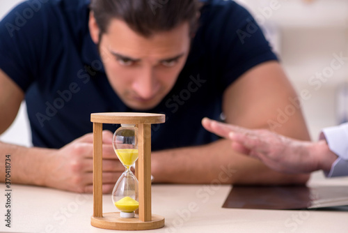 Young male patient visiting old doctor in antismoking concept