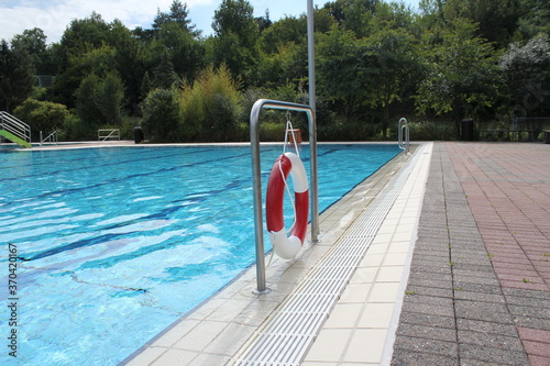big empty swimming pool in summer with lifebuoy