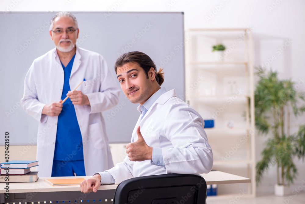 Experienced doctor teaching young male assistant Experienced doctor teaching young male assistant