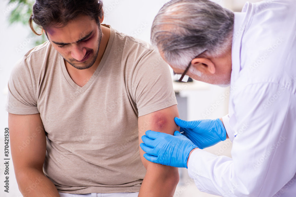 Obraz premium Young face injured man visiting experienced male doctor traumato