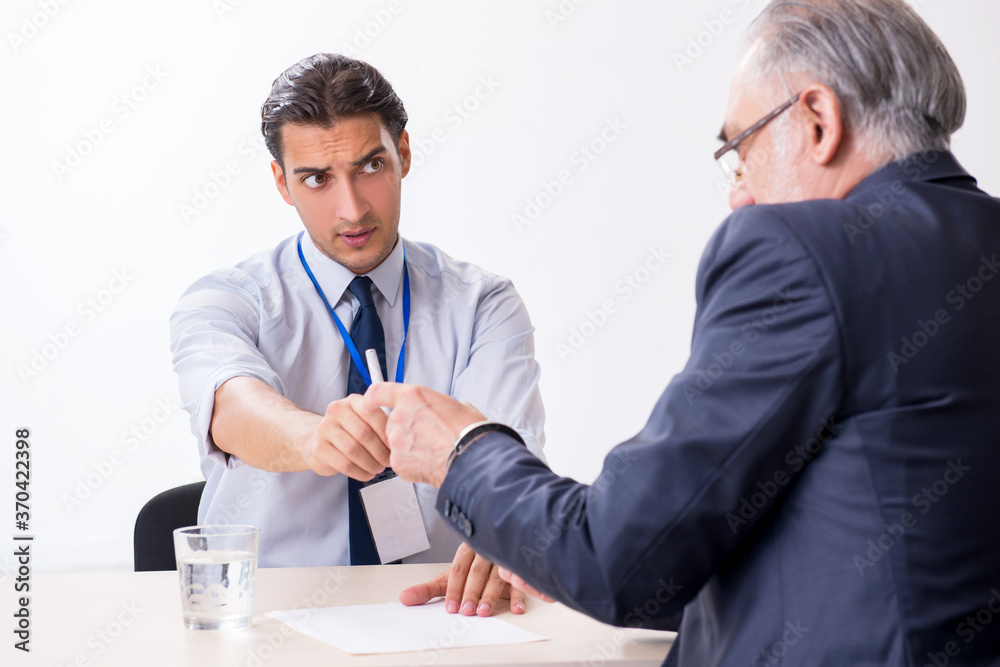 Old businessman meeting with advocate in pre-trial detention Old businessman meeting with advocate in pre-trial detention