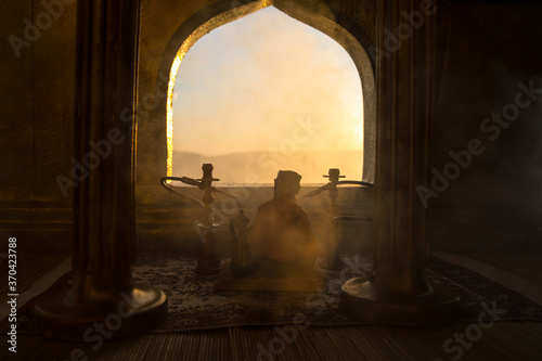 A realistic Arabian interior miniature with window and columns. Hookah hot coals on shisha bowl making clouds of steam. Stylish oriental shisha miniature