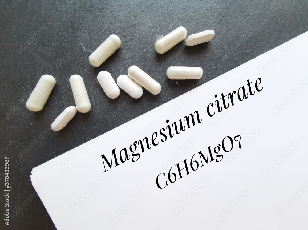 Chemical formula of magnesium citrate molecule with white pills