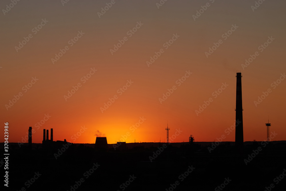 Dramatic sunset on the sky and coal power plant factory. Petrochemical industrial plant. Oil and gas refinery tower in silhouette. Refinery for petroleum products Dramatic sunset on the sky and coal power plant factory. Petrochemical industrial plant. Oil and gas refinery tower in silhouette. Refinery for petroleum products
