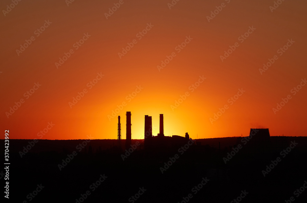 Dramatic sunset on the sky and coal power plant factory. Petrochemical industrial plant. Oil and gas refinery tower in silhouette. Refinery for petroleum products Dramatic sunset on the sky and coal power plant factory. Petrochemical industrial plant. Oil and gas refinery tower in silhouette. Refinery for petroleum products