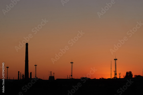 Dramatic sunset on the sky and coal power plant factory. Petrochemical industrial plant. Oil and gas refinery tower in silhouette. Refinery for petroleum products