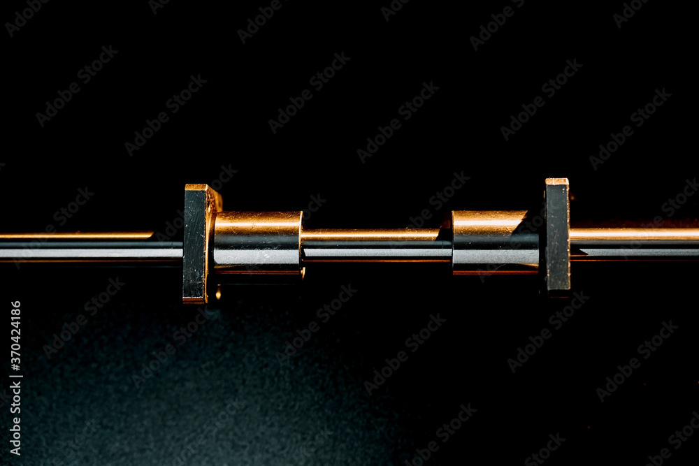 motor and guides for the laser machine. details of the engraving machine, black warm background, orange light. motor and guides for the laser machine. details of the engraving machine, black warm background, orange light.