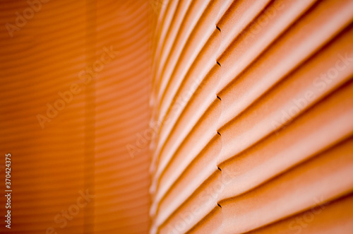 detail of a building, with wavy lines, made with material of prefabricated panels of red concrete that recalls the silhouettes such as sand dunes in the desert smoothed by the wind, of the sea photo