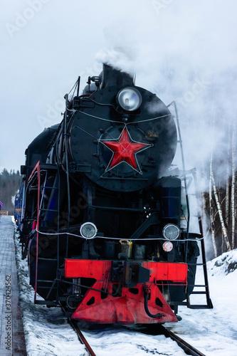 Vintage black steam locomotive train rush railway. winter photo