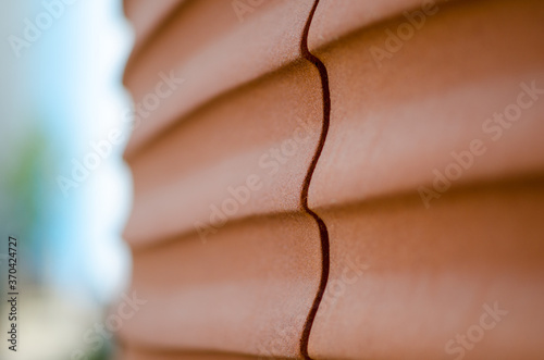 detail of a building, with wavy lines, made with material of prefabricated panels of red concrete that recalls the silhouettes such as sand dunes in the desert smoothed by the wind, of the sea photo