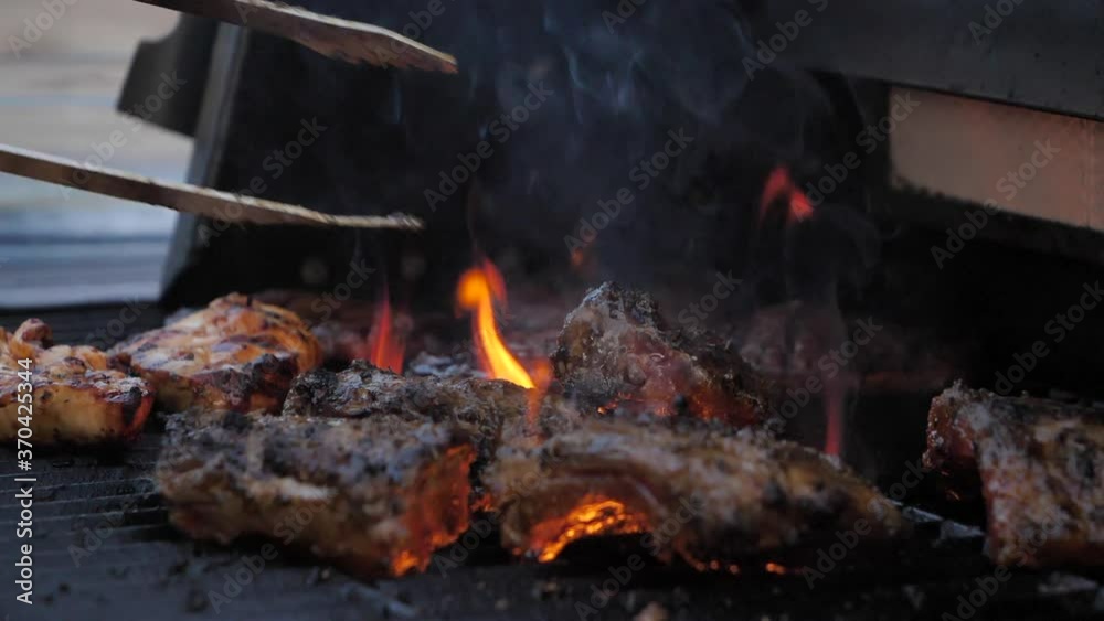 Turning around meat with cooking pliers, barbecue flame grill SLOMO Turning around meat with cooking pliers, barbecue flame grill SLOMO