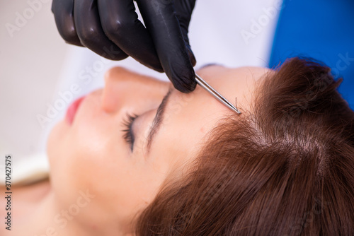 Young woman visiting male beautician in hair transplantation con