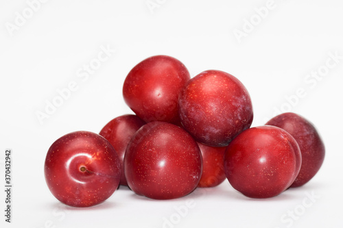 Fresh Fruits from India Red Plums known as Alubukhara or Aloobukhara in Indian Subcontinent. Heap of fruits on white background. Cherry plum