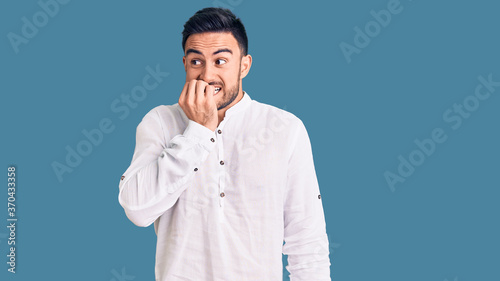 Fotografie Young handsome man wearing casual clothes looking stressed and nervous with hands on mouth biting nails