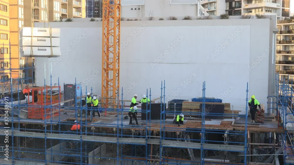 Growing apartment building as a construction site with men at work – 4k ...