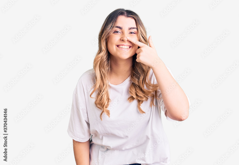 Young caucasian woman wearing casual clothes pointing with hand finger to face and nose, smiling cheerful. beauty concept Young caucasian woman wearing casual clothes pointing with hand finger to face and nose, smiling cheerful. beauty concept