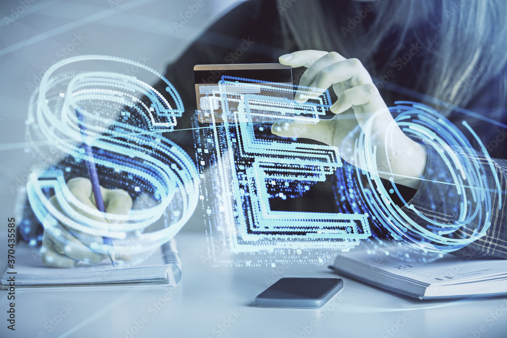 Double exposure of woman on-line shopping holding a credit card and SEO hologram drawing. Search optimization E-commerce concept. Double exposure of woman on-line shopping holding a credit card and SEO hologram drawing. Search optimization E-commerce concept.