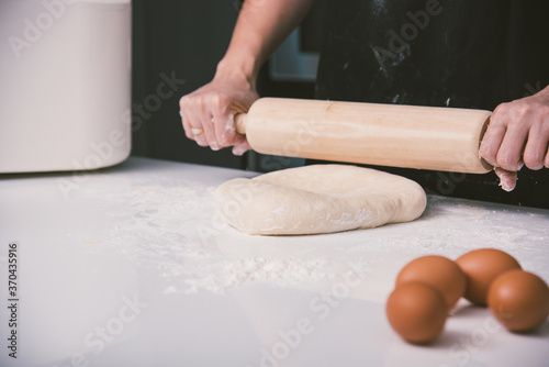Hand of baker woman female making dough pastry pie with rolling wooden