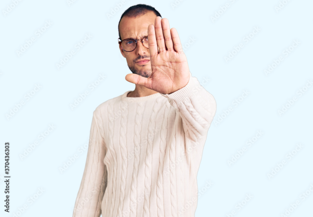 Young handsome man wearing casual clothes and glasses doing stop sing with palm of the hand. warning expression with negative and serious gesture on the face. Young handsome man wearing casual clothes and glasses doing stop sing with palm of the hand. warning expression with negative and serious gesture on the face.