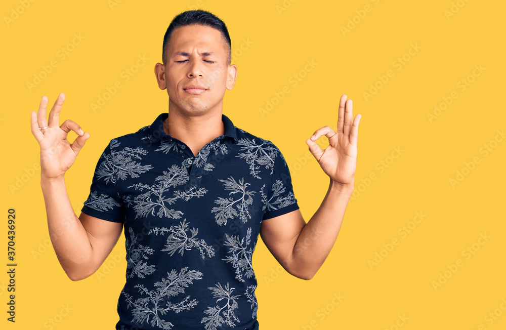 Young handsome latin man wearing casual clothes relax and smiling with eyes closed doing meditation gesture with fingers. yoga concept.
