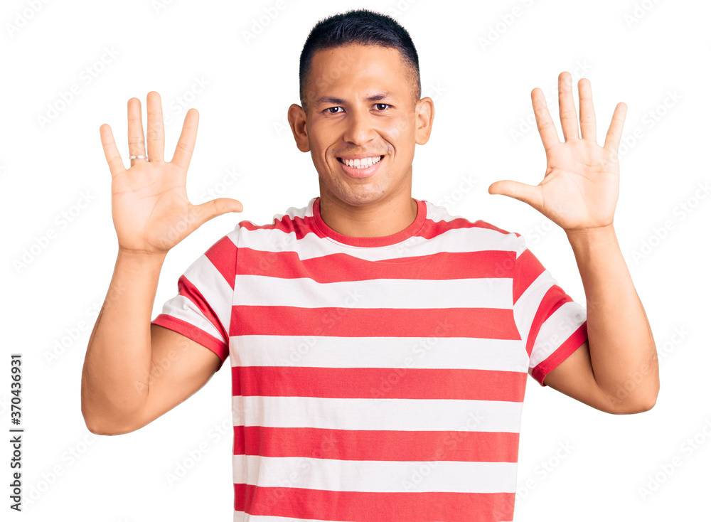 Young handsome latin man wearing casual clothes showing and pointing up with fingers number ten while smiling confident and happy. Young handsome latin man wearing casual clothes showing and pointing up with fingers number ten while smiling confident and happy.