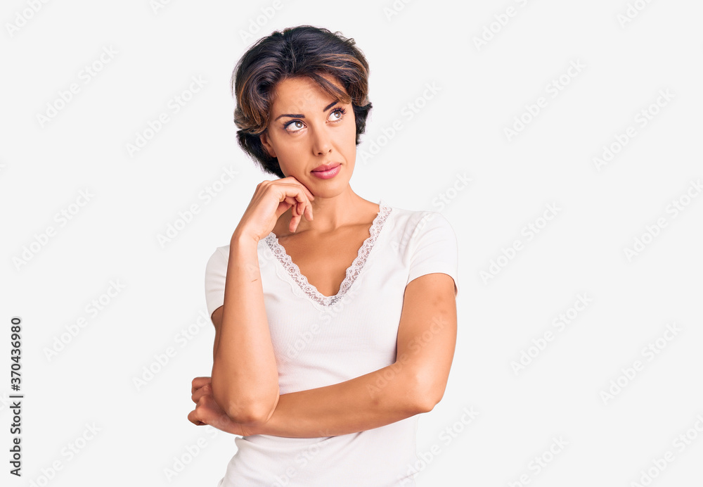 Young beautiful woman wearing casual clothes serious face thinking about question with hand on chin, thoughtful about confusing idea Young beautiful woman wearing casual clothes serious face thinking about question with hand on chin, thoughtful about confusing idea