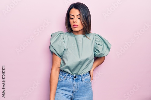 Young beautiful brunette woman wearing casual clothes standing over isolated pink background © Krakenimages.com
