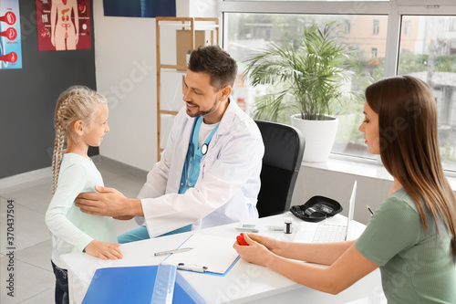 Pediatrician examining a yo...