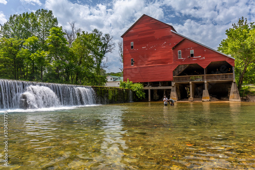 An old red mill and a dam. photo