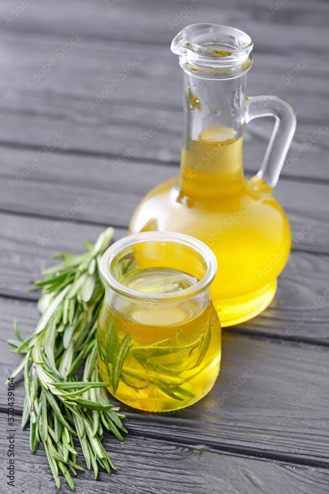 Bottle and jar of rosemary oil on table Bottle and jar of rosemary oil on table