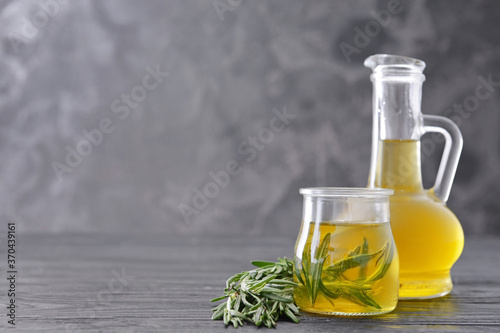 Bottle and jar of rosemary oil on table