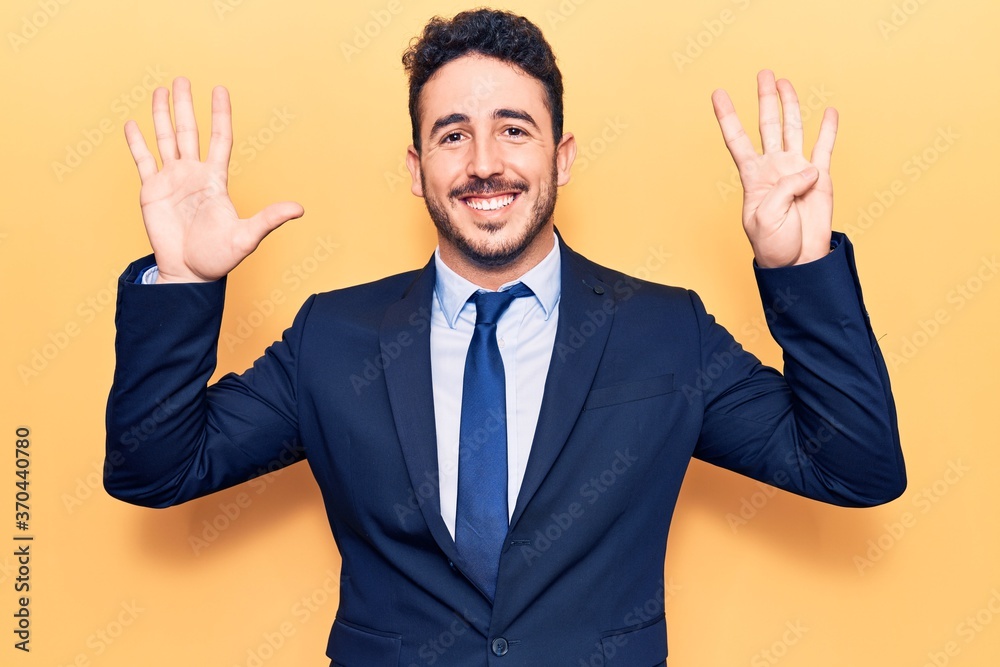 Young hispanic man wearing suit showing and pointing up with fingers number nine while smiling confident and happy. Young hispanic man wearing suit showing and pointing up with fingers number nine while smiling confident and happy.