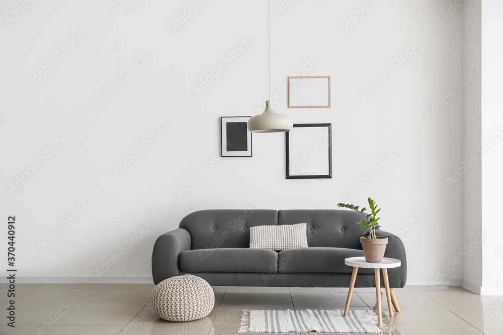 Sofa near wall in interior of living room - obrazy, fototapety, plakaty 