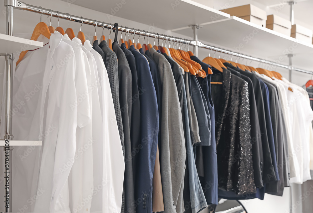 Hanger with stylish clothes in modern store