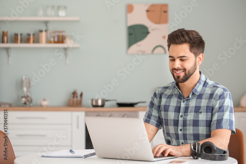 Young man using laptop for ...