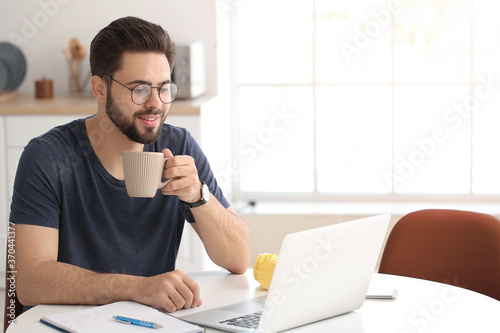 Young man using laptop for ...