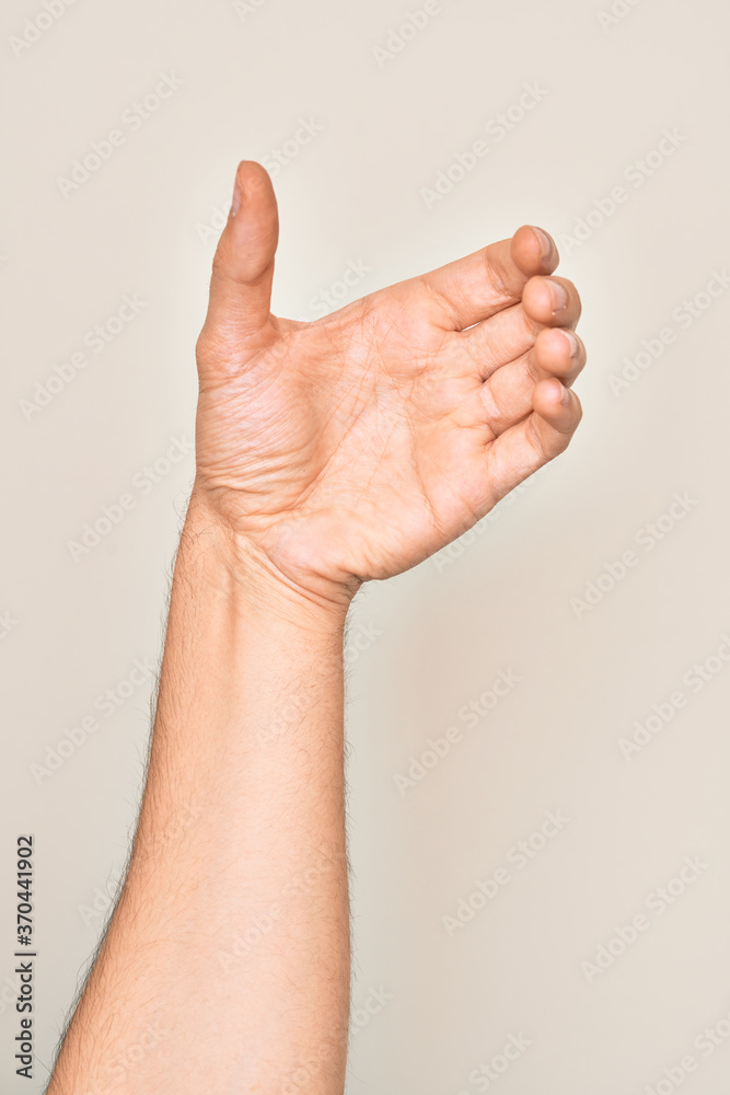 Hand of caucasian young man showing fingers over isolated white background holding invisible object, empty hand doing clipping and grabbing gesture