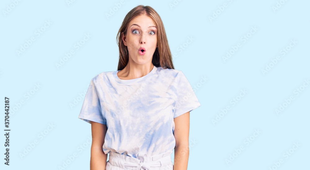 Young beautiful blonde woman wearing tye die tshirt scared and amazed with open mouth for surprise, disbelief face Young beautiful blonde woman wearing tye die tshirt scared and amazed with open mouth for surprise, disbelief face