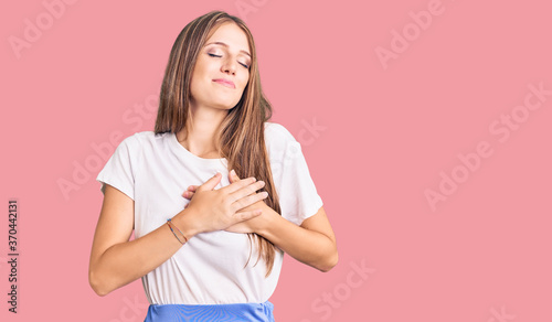 Young beautiful blonde woman wearing summer style smiling with hands on chest with closed eyes and grateful gesture on face. health concept.