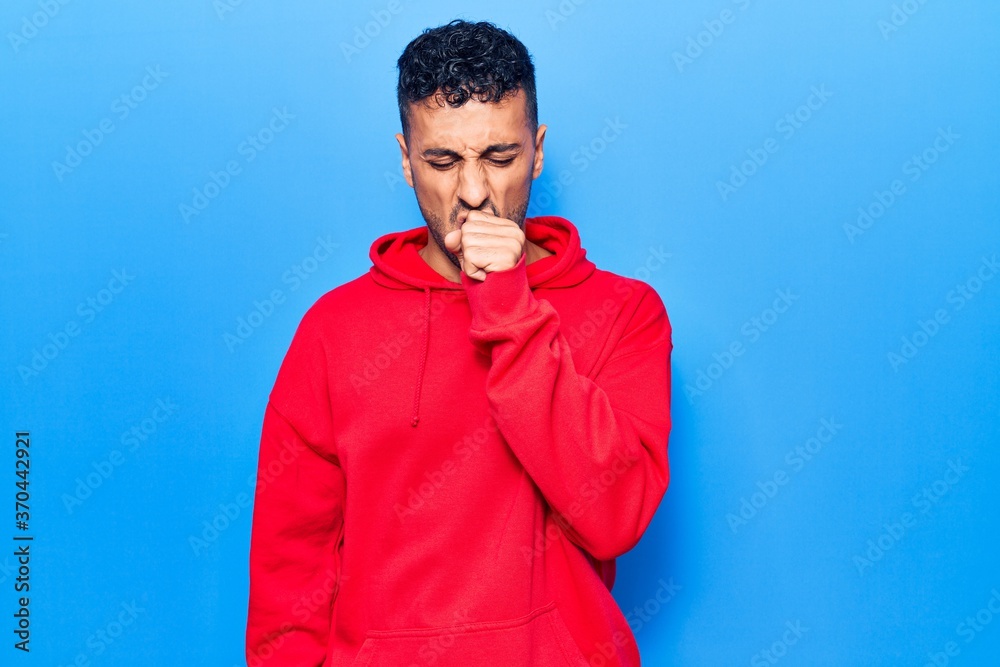 Young hispanic man wearing casual clothes feeling unwell and coughing as symptom for cold or bronchitis. health care concept. Young hispanic man wearing casual clothes feeling unwell and coughing as symptom for cold or bronchitis. health care concept.