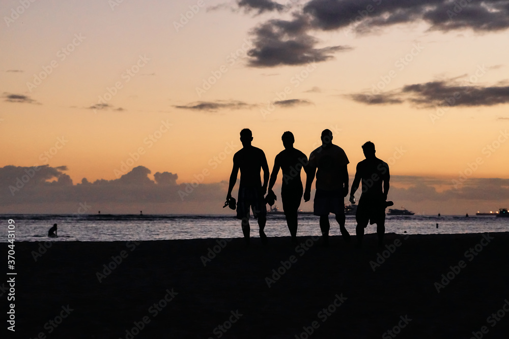 ハワイ・ワイキキビーチを歩く人々のシルエット