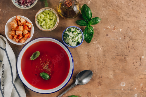 Spanish summer cold soup gazpacho with vegetables on beige rustic background.