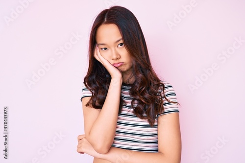 Young beautiful chinese girl wearing casual clothes thinking looking tired and bored with depression problems with crossed arms. © Krakenimages.com