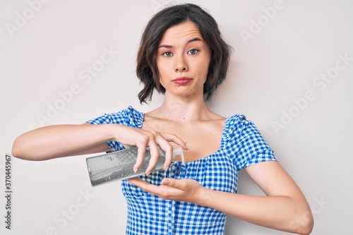 Young beautiful woman using hand sanitizer gel skeptic and nervous, frowning upset because of problem. negative person. © Krakenimages.com