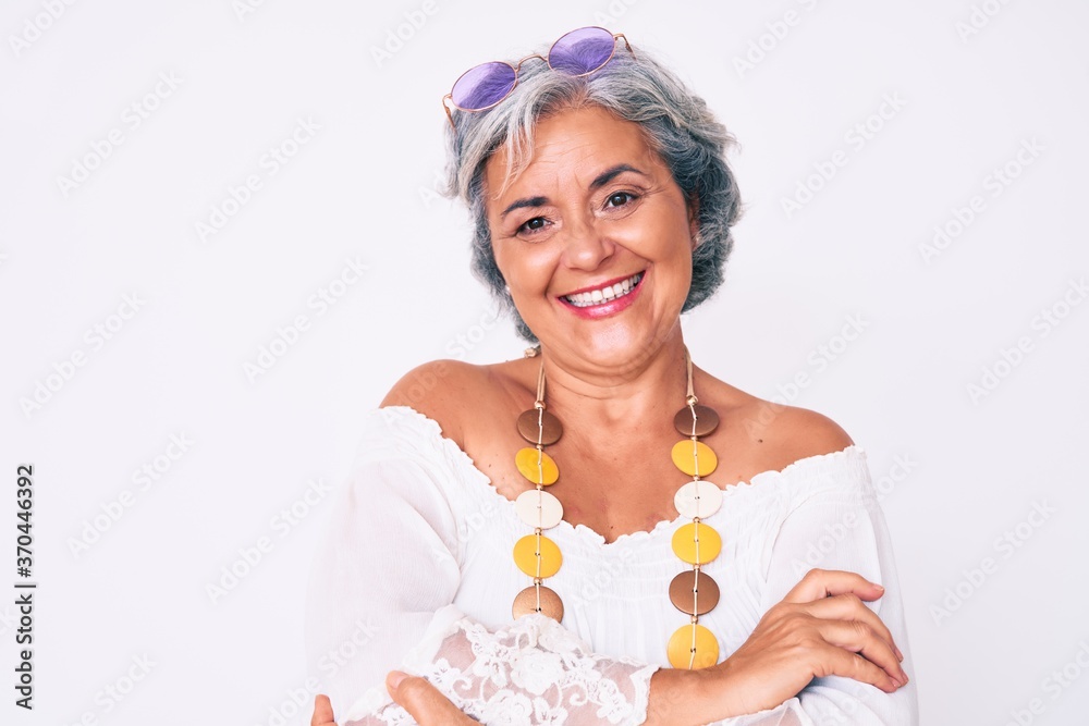 Senior hispanic grey- haired woman wearing casual hippie clothes happy face smiling with crossed arms looking at the camera. positive person. Senior hispanic grey- haired woman wearing casual hippie clothes happy face smiling with crossed arms looking at the camera. positive person.