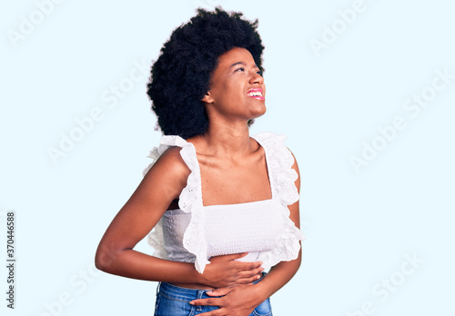 Young african american woman wearing casual clothes with hand on stomach because nausea, painful disease feeling unwell. ache concept.